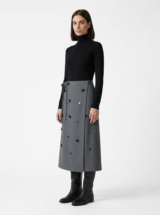 Woman wearing a long gray coat with black buttons on a white background