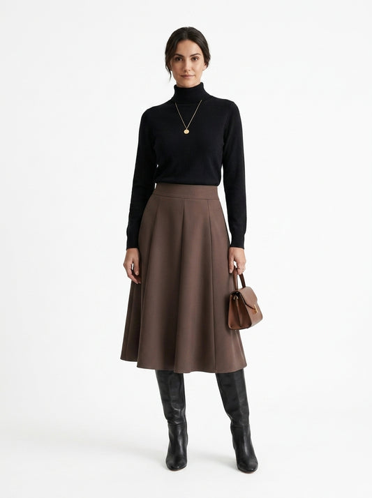 Woman wearing a black turtleneck, brown skirt, and black knee-high boots on a white background