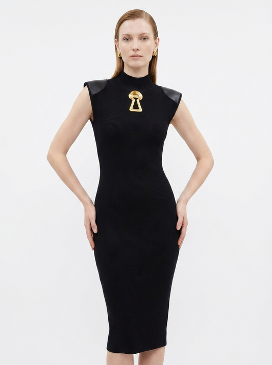 Black dress with gold accents worn by a model on a white background