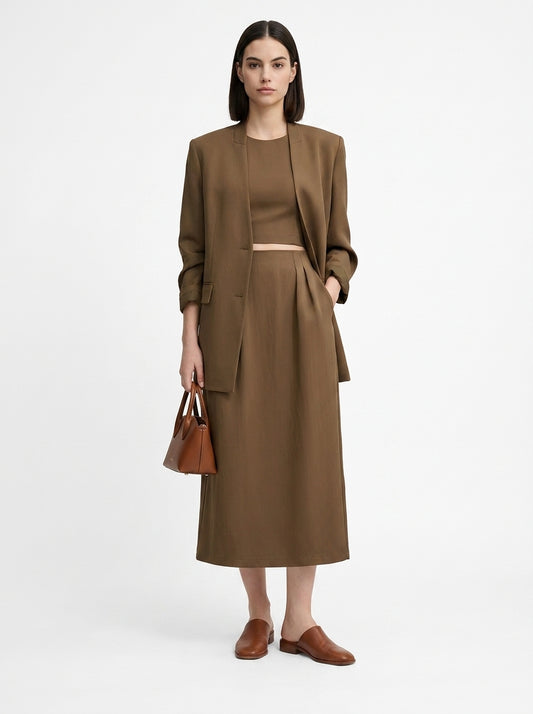 Woman wearing a brown suit with a matching handbag on a white background