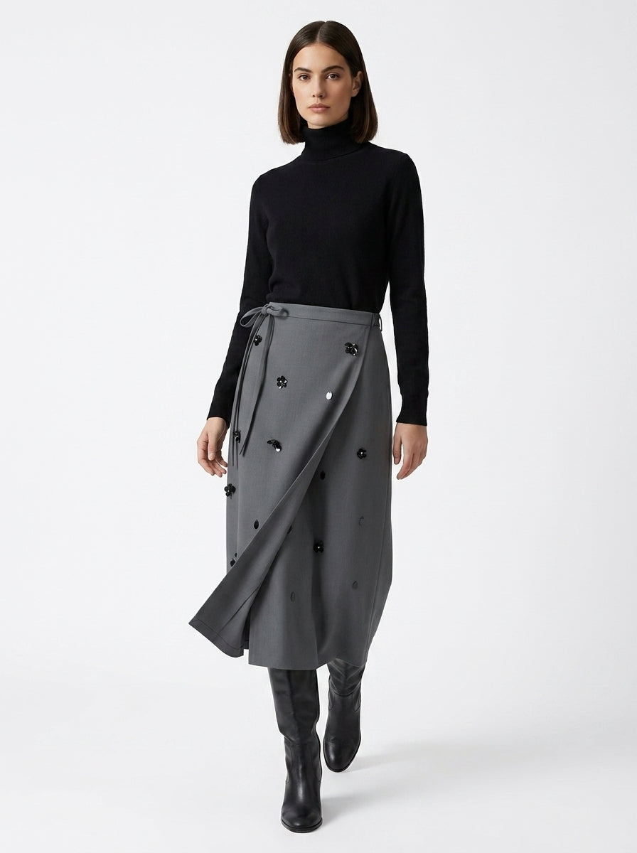 Woman wearing a black turtleneck and gray skirt on a white background