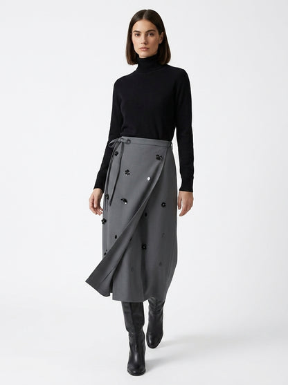 Woman wearing a black turtleneck and gray skirt on a white background