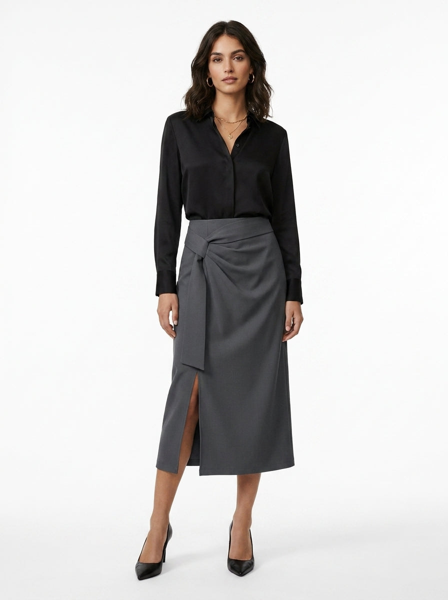 Woman wearing a black shirt and gray skirt on a white background