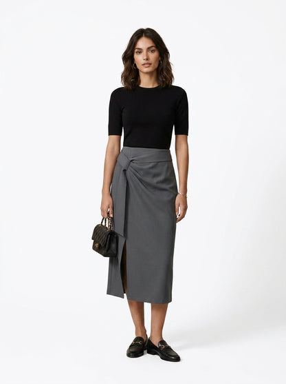 Woman wearing a black top and gray skirt with a white background