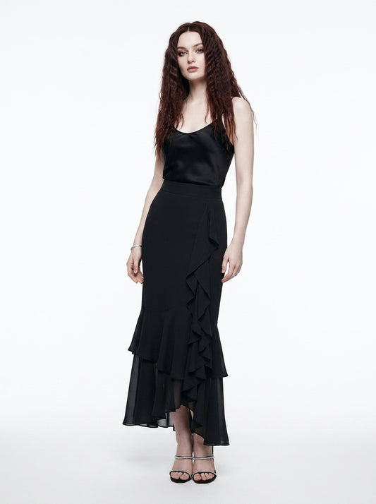 Woman wearing a black dress with ruffled layers on a white background