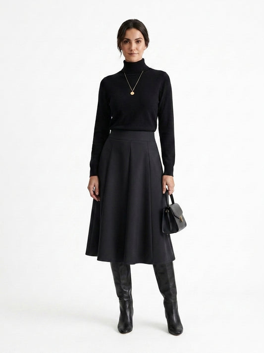 Woman wearing a black turtleneck, black skirt, and black boots on a white background