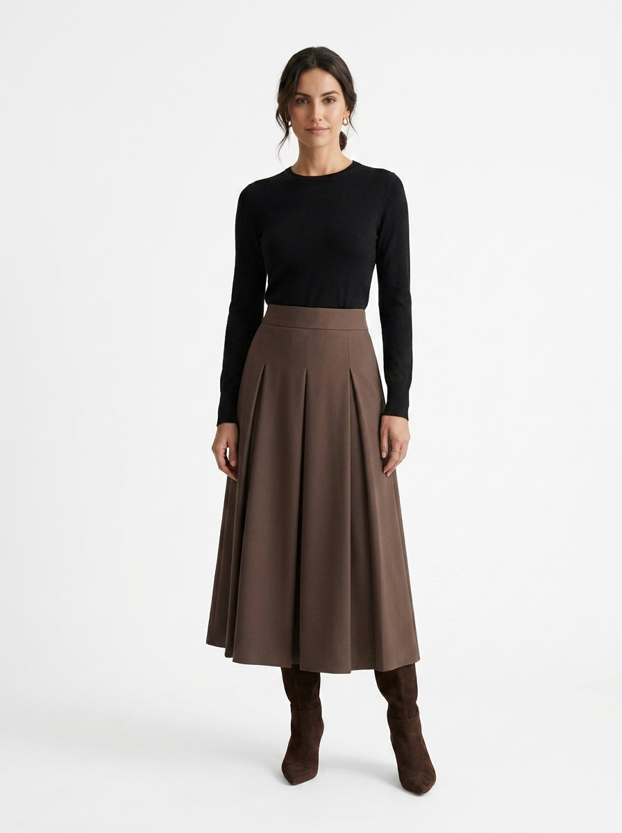 Woman wearing a black top and brown skirt on a white background