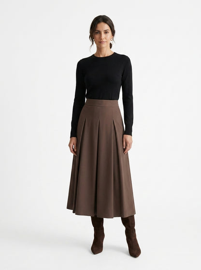 Woman wearing a black top and brown skirt on a white background