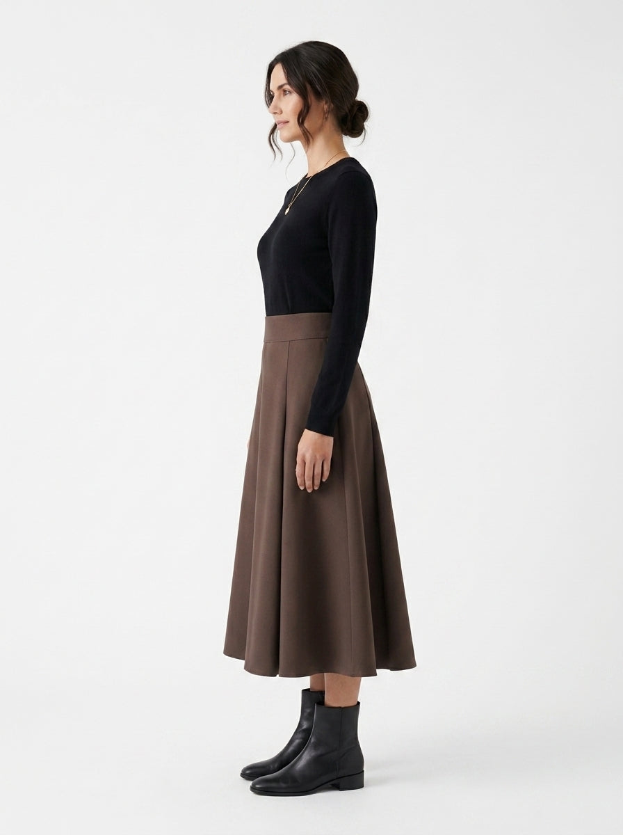 Woman wearing a black top and brown skirt on a white background