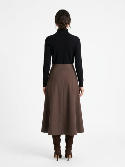 Person wearing a black turtleneck and brown skirt on a white background
