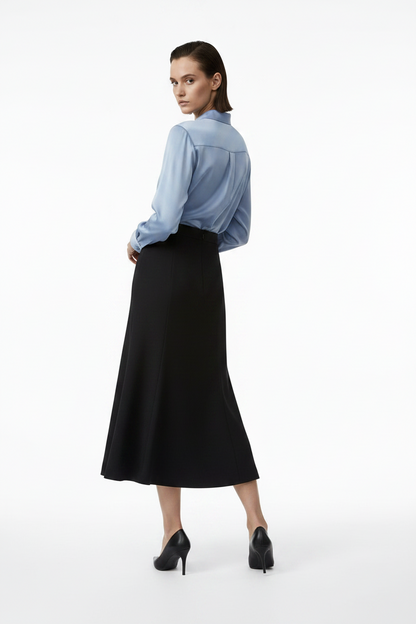 Woman wearing a blue shirt and black skirt on a white background