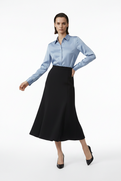 Woman wearing a light blue shirt and black skirt on a white background