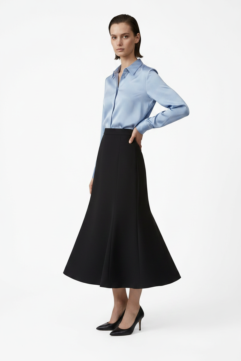 Woman wearing a light blue shirt and black skirt on a white background