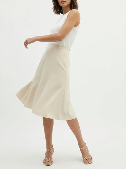 Woman wearing a white sleeveless top and beige skirt on a white background