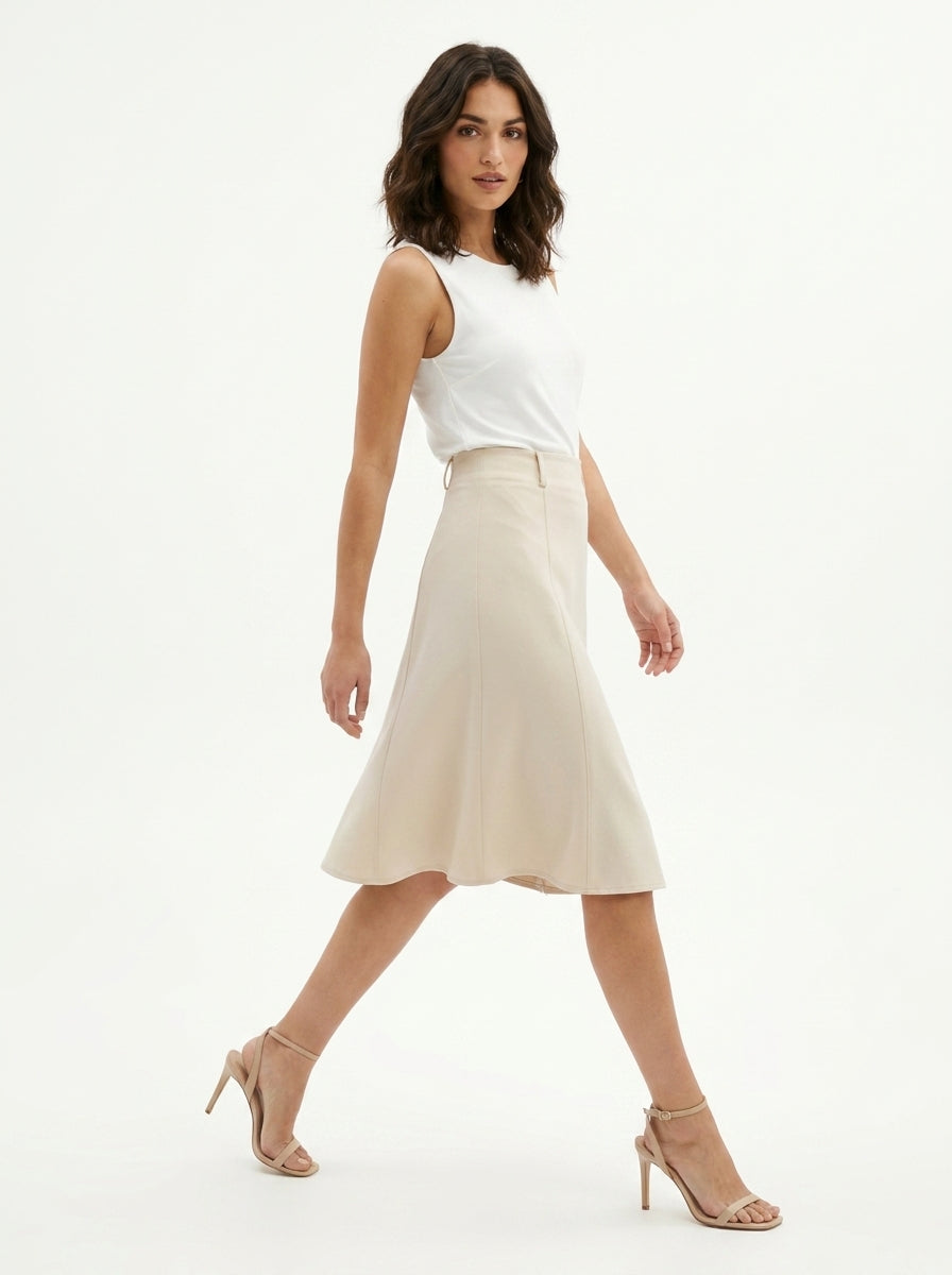 Woman wearing a white sleeveless top and beige skirt on a white background