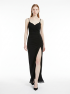 Woman wearing a black evening gown with a slit on a white background