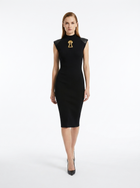 Woman wearing a black dress with a gold brooch on a white background