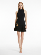 Woman wearing a black dress with a gold buckle on a white background