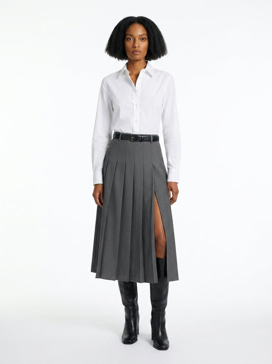 Woman wearing a white shirt and gray pleated skirt with a slit on a white background