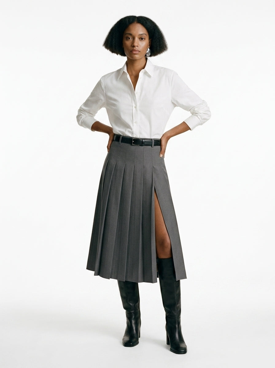 Woman wearing a white shirt, gray skirt, and black boots on a white background