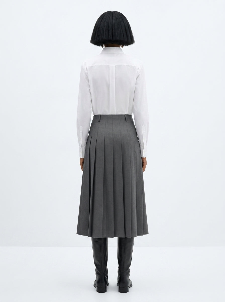 Person wearing a white shirt and gray skirt on a white background